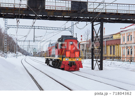 shunting locomotive on a railway track in an industrial area on a winter day shunting locomotive on a railway track in an industrial area on a winter day 71804362