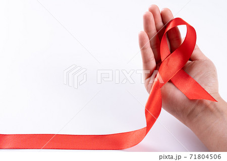 Aids awareness, woman hands holding red ribbon on white background with copy space for text. World Aids Day, Healthcare and medical concept. 71804506