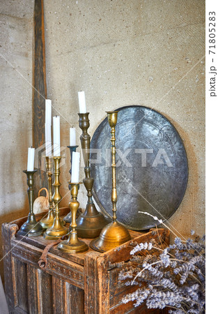 Vintage candles and candle holders onto antique furniture 71805283