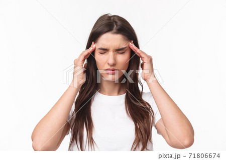 Close-up portrait of woman trying calm down, feeling migraine or terrible headache, suffer pain, massaging temples frowning and close eyes, controlling emotions, white background Close-up portrait of woman trying calm down, feeling migraine or terrible headache, suffer pain, massaging temples frowning and close eyes, controlling emotions, white background 71806674