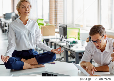 business womans meditating at work place on table business womans meditating at work place on table 71807920