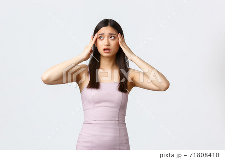Luxury women, party and holidays concept. Anxious and panicking young asian woman in elegant dress, worried about guests and celebration, holding hands on head and looking aside nervous Luxury women, party and holidays concept. Anxious and panicking young asian woman in elegant dress, worried about guests and celebration, holding hands on head and looking aside nervous 71808410