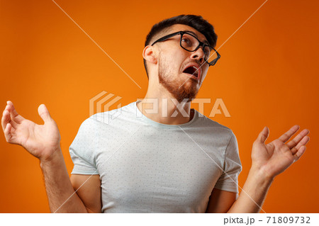 Portrait of young nerd man shrugging shoulders, I don't know gesture Portrait of young nerd man shrugging shoulders, I don't know gesture 71809732