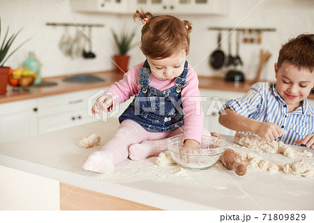 Boy and girl littered in flour in the kitchen Boy and girl littered in flour in the kitchen 71809829