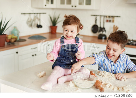 Boy and girl littered in flour in the kitchen 71809830