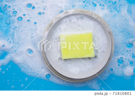 Washing dishes on wet blue background with soapy foam. Washing dishes on wet blue background with soapy foam. 71810801
