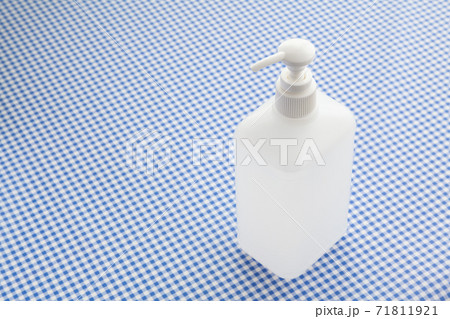 水色のギンガムチェックの布の上に置かれた手指消毒用アルコール液 水色のギンガムチェックの布の上に置かれた手指消毒用アルコール液 71811921
