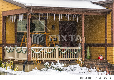 Rustic brown home in Daybreak Utah viewed through falling snow in winter 71813513