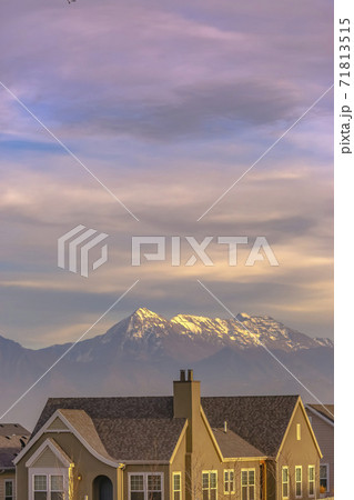 Facade of a home viewed against a snow capped mountain in the background Facade of a home viewed against a snow capped mountain in the background 71813515