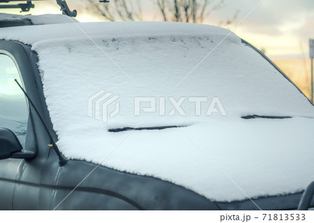 Close up of a snowy black vehicle with the horizon in the background at sunset Close up of a snowy black vehicle with the horizon in the background at sunset 71813533