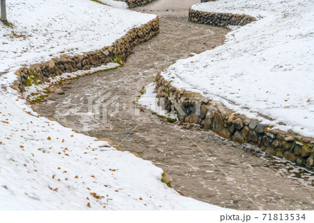 Park in Salt Lake City with a creek winding in the middle of a snowy terrain Park in Salt Lake City with a creek winding in the middle of a snowy terrain 71813534