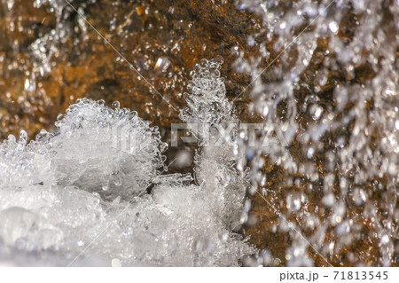 Close up of crystalline ice and brown rock covered with shiny frozen water Close up of crystalline ice and brown rock covered with shiny frozen water 71813545