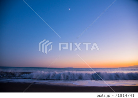半月と日没後の波が打ち寄せる湘南の海 半月と日没後の波が打ち寄せる湘南の海 71814741
