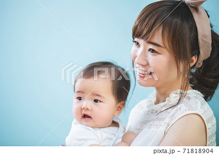 赤ちゃんを抱っこする笑顔の若いママの写真素材