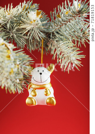Bull figure on a Christmas tree on a red background, free space for text. Bull figure on a Christmas tree on a red background, free space for text. 71819153