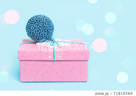 Red Christmas gift box with blue bauble on blue Red Christmas gift box with blue bauble on blue 71819569