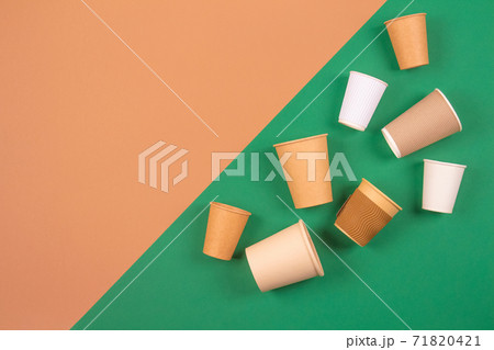 Different eco-friendly takeaway beverages cups - kraft paper coffee cups on green and brown background with copyspace. Recycled kraft paper tableware and zero waste concept, mockup image 71820421