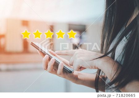 Close-up image of woman hand using mobile smart phone with icon five star 71820665