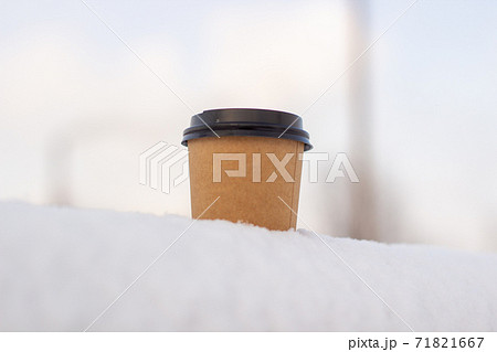 Cardboard coffee Cup in the snow in winter. Hot drink tea or coffee Cardboard coffee Cup in the snow in winter. Hot drink tea or coffee 71821667
