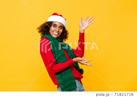 Cheerful happy woman in Christmas attire smiling and raising hands up 71821716