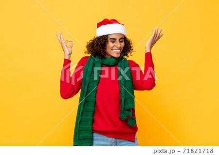 Surprised happy woman in Christmas attire smiling and raising hands up Surprised happy woman in Christmas attire smiling and raising hands up 71821718