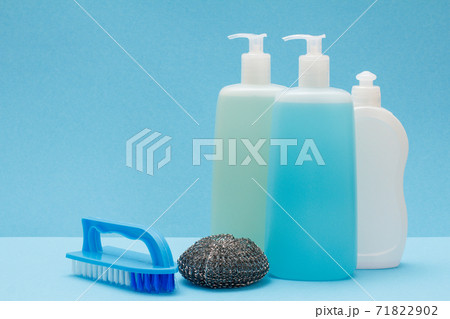 Bottles of dishwashing liquid, brush and sponge on blue background. 71822902