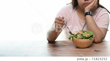 Cropped shot of an unhappy overweight woman bored of diets eating healthy food. 71823252