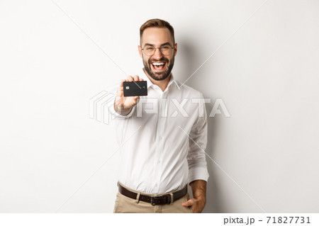 Excited caucasian man in glasses showing credit card, concept of shopping Excited caucasian man in glasses showing credit card, concept of shopping 71827731