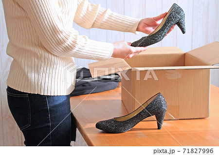 荷物の前でパンプスをチェックする女性 71827996