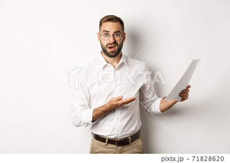 Disappointed boss scolding for bad report, pointing at documents and looking confused, standing over white background 71828620