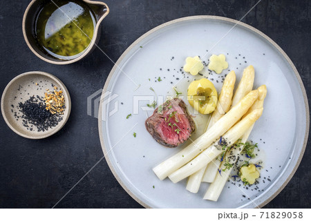 dry aged sliced fillet steak with white asparagus and roast potatoes 71829058