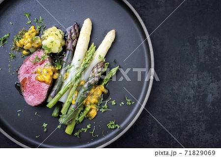 dry aged sliced fillet steak with green, white and lilac asparagus  71829069