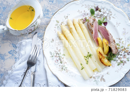 Traditional sliced pork fillet steak with white asparagus in butter sauce and roast potatoes 71829083