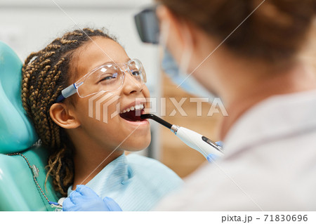 Dentist curing patient's teeth Dentist curing patient's teeth 71830696