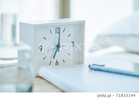 15/50文字 卓上の目覚まし時計とスマホと本 71833144
