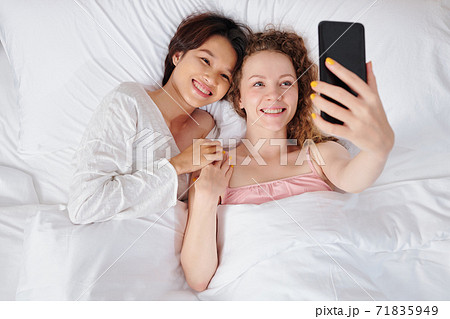 Couple taking selfie in bed 71835949
