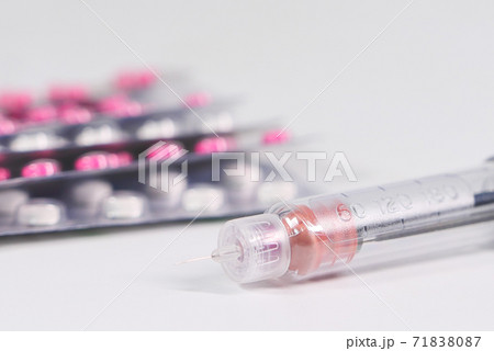 Insulin pen and pills on white background with copy space  71838087