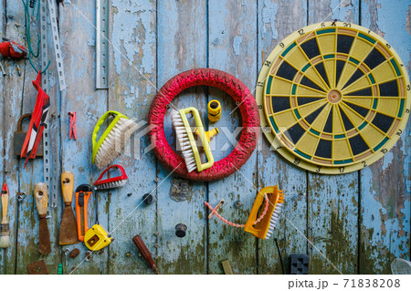 Various tools and supplies hanging on shabby wooden wall 71838208