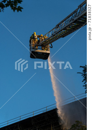 Firefighters climbing ladder against building. Selective focus Firefighters climbing ladder against building. Selective focus 71838327