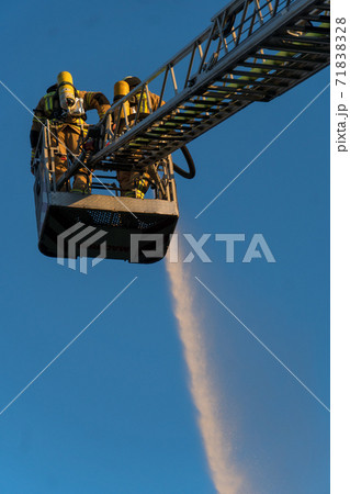 Firefighters extinguishing a blaze 71838328