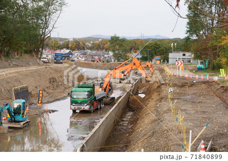 水路工事現場でのパワーショベルによる土砂のダンプカーへの積み上げ 水路工事現場でのパワーショベルによる土砂のダンプカーへの積み上げ 71840899