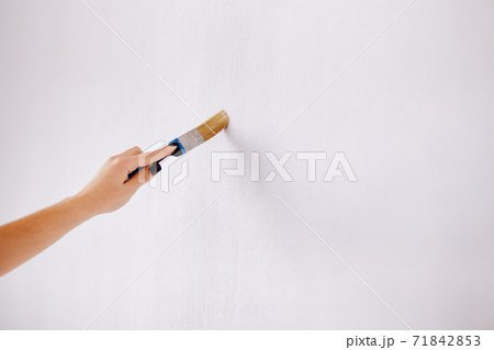A woman in a pink jumpsuit is painting a wall. Renovation and new life A woman in a pink jumpsuit is painting a wall. Renovation and new life 71842853