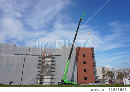 建築現場・クレーン車で資材を吊り上げ 71843698