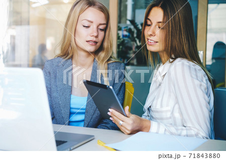 Women coworkers sitting in coworking office near computer with mock up screen 71843880