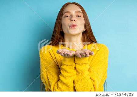 Studio shot of redhead caucasian young woman isolated blue background Studio shot of redhead caucasian young woman isolated blue background 71844508