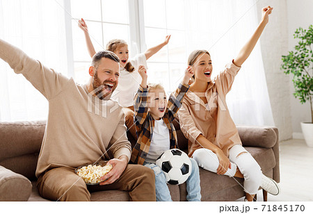 Excited family watching football at home. Excited family watching football at home. 71845170