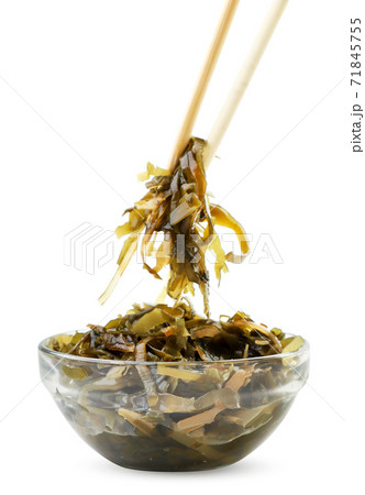 Seaweed salad in a glass plate and chopsticks on a white background. Isolated Seaweed salad in a glass plate and chopsticks on a white background. Isolated 71845755