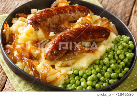 Irish Bangers and Mash is a dish consisting of sausages served with mashed potatoes and onion gravy closeup in the plate. horizontal Irish Bangers and Mash is a dish consisting of sausages served with mashed potatoes and onion gravy closeup in the plate. horizontal 71846580