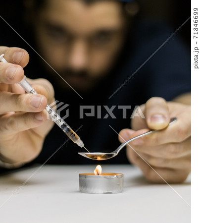 A man preparing a dose of cocaine. A man preparing a dose of cocaine. 71846699