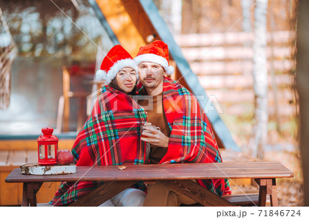 Young family in santa hat sitting on the wooden old table background of their house Young family in santa hat sitting on the wooden old table background of their house 71846724